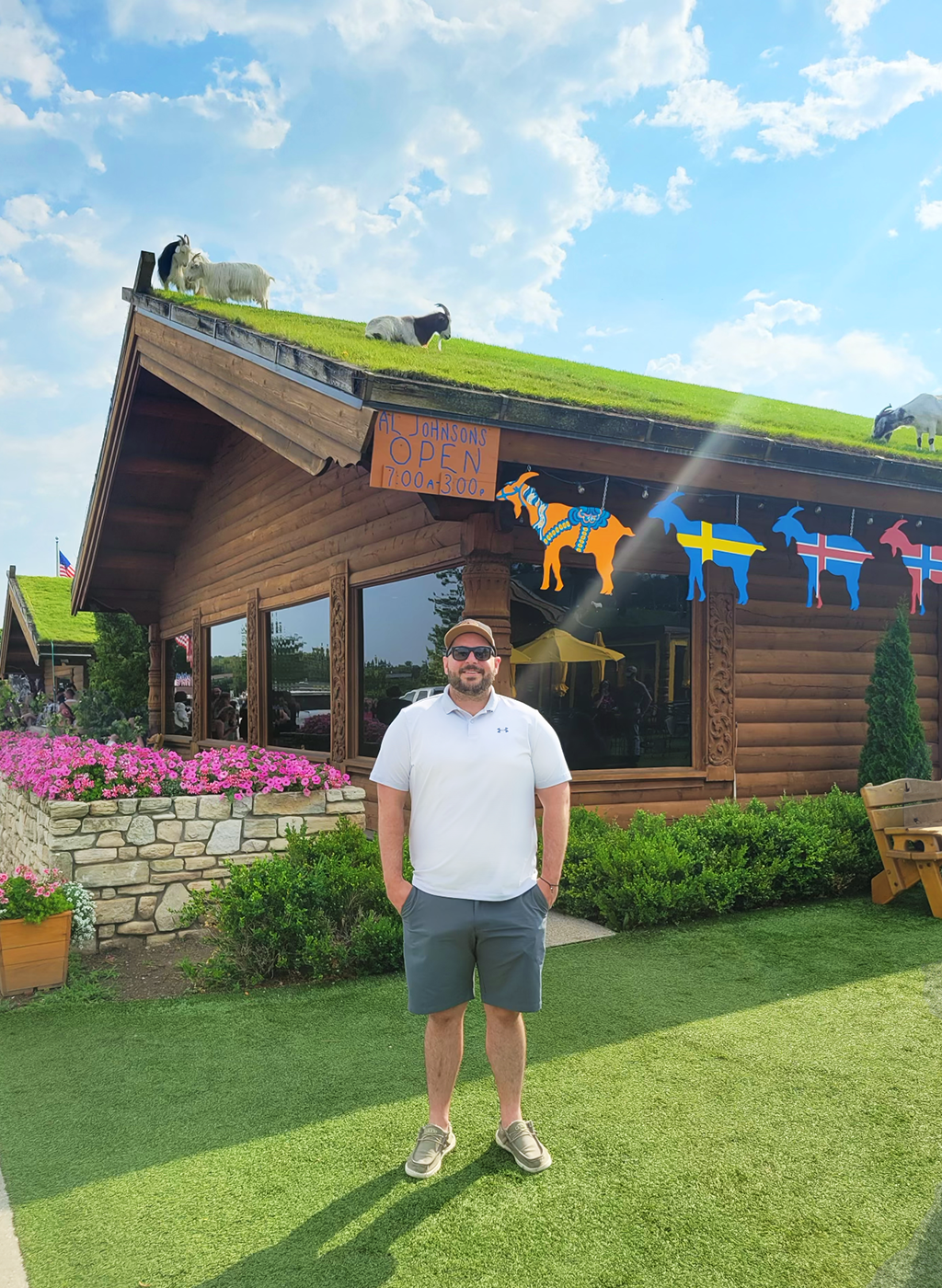 Man who loves goats and hates getting his picture taken stands for a picture with goats